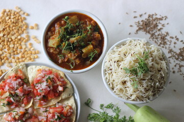 Indian dish made of basmati rice flavoured with cumin seeds and spices. Served with Bottle Gourd Curry with Lentils and Crisp and fried papads topped with masala filling