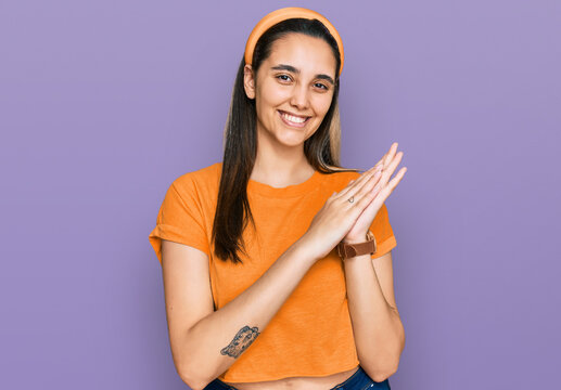 Young hispanic woman wearing casual clothes clapping and applauding happy and joyful, smiling proud hands together
