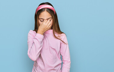 Beautiful brunette little girl wearing casual turtleneck sweater tired rubbing nose and eyes feeling fatigue and headache. stress and frustration concept.