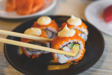 California roll and cut served in black plate.