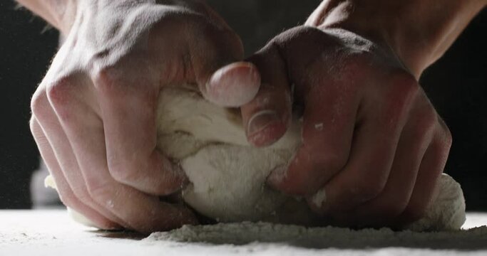 Hands of professional baker kneading dough. Chef carefully making bread with traditional recipe food and drink close up 4k footage
