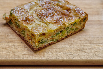 homemade pie with vegetables and green beans on a wooden cutting board