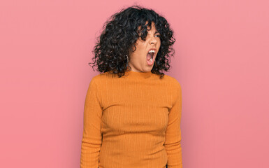 Fototapeta na wymiar Young hispanic woman wearing casual clothes angry and mad screaming frustrated and furious, shouting with anger. rage and aggressive concept.