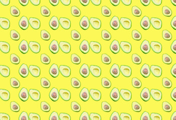 A pattern with different avocado halves on a yellow background.