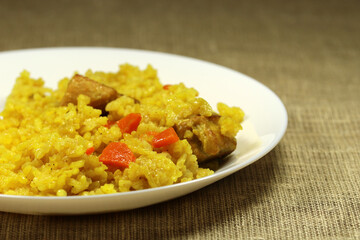 Traditional asian dish - pilaf from rice, vegetables and meat in a white plate. Selective focus.