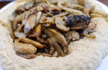 Traditional Mediterranean hummus with mushrooms and onions. Classic Hummus with paprika, olive oil, onions, mushrooms and seasonings
