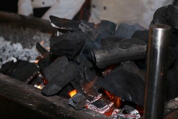 Barbecue coal on grill pit, with Glowing And Flaming Hot Charcoal Briquettes 