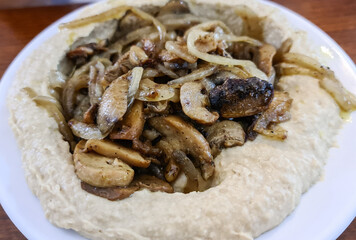 Traditional Mediterranean hummus with mushrooms and onions.