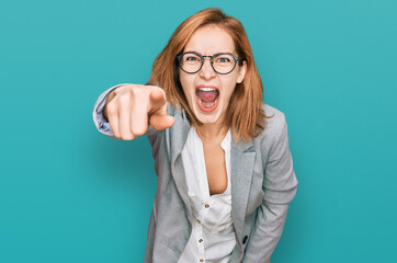 Young caucasian woman wearing business style and glasses pointing displeased and frustrated to the...