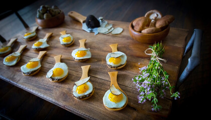 partridge eggs with truffle and mushroom served on a rustic tray