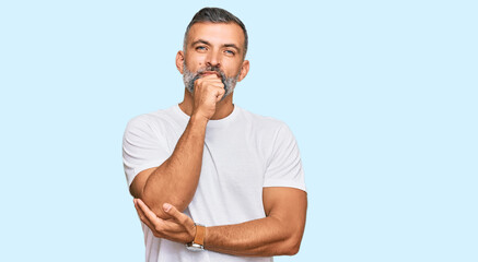 Middle age handsome man wearing casual white tshirt with hand on chin thinking about question,...