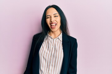 Fototapeta premium Young hispanic girl wearing business clothes winking looking at the camera with sexy expression, cheerful and happy face.