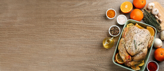 Fototapeta na wymiar Raw chicken, orange slices and other ingredients on wooden table, flat lay. Space for text