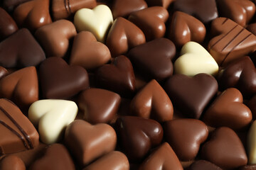 Beautiful heart shaped chocolate candies on brown background