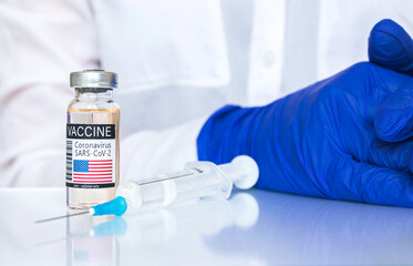 USA vaccine against coronavirus, vaccine vial concept with syringe, medical background with doctor hands