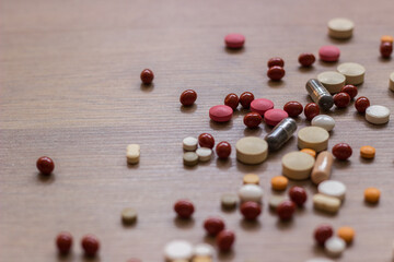 A photo of different medicinal drugs, tablets and pills on wooden background