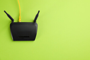 Modern Wi-Fi router on green background, top view. Space for text - obrazy, fototapety, plakaty
