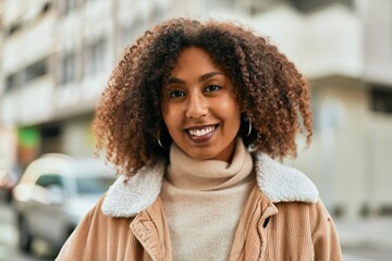 Young african american woman smiling happy standing at the city.