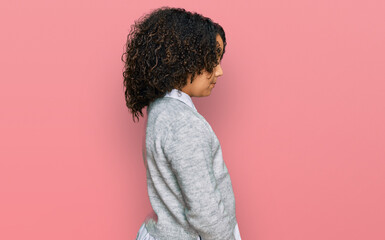 Young little girl with afro hair wearing casual clothes looking to side, relax profile pose with natural face with confident smile.