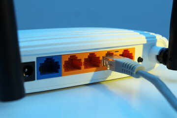 Connected cable to router on white table, closeup. Wireless internet communication