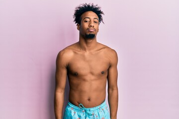 Fototapeta premium Young african american man with beard wearing swimsuit depressed and worry for distress, crying angry and afraid. sad expression.