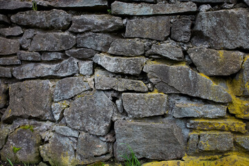 Texture of a stone grey wall with moss