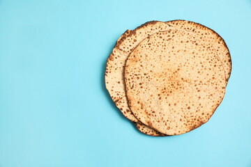 Tasty matzos on light blue background, flat lay with space for text. Passover (Pesach) celebration
