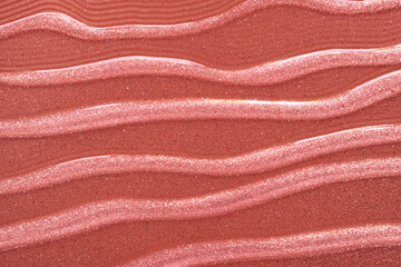 Cosmetic shimmering lip gloss oil gel pink red texture background