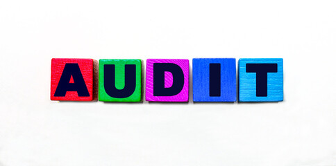 The word AUDIT is written on colorful cubes on a light background