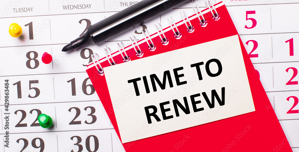 Poster on the calendar is a white card with the text time to renew. nearby is a red notepad and a marker. v