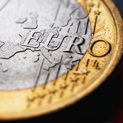 Fragment of a coin of 1 one euro. In focus inscription with the name of the Eurozone currency....