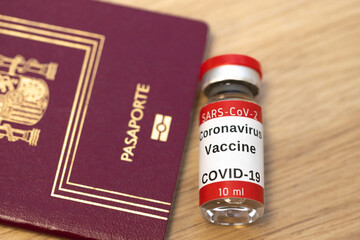 Spanish passport and coronavirus vaccine. Medical test at border control and in airport. Business and tourism hit by pandemic. Health passport. Coronavirus and travel concept.