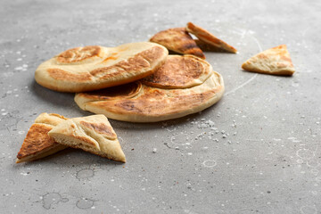 Fresh pita on a stone table.. Still life of food. Georgian cuisine. Spanish food. National cuisine.