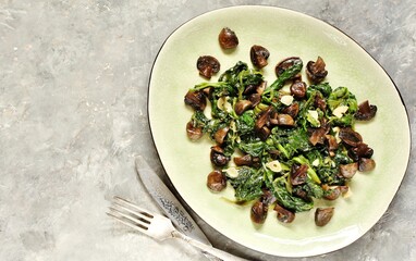 fried champignons with spinach in a plate.
top view. Copy space.