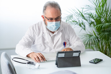 Doctor having a video conference with tablet in his office 