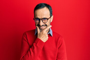 Middle age hispanic man wearing casual clothes and glasses looking confident at the camera smiling with crossed arms and hand raised on chin. thinking positive.