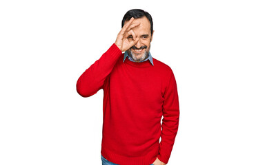Middle age hispanic man wearing casual clothes doing ok gesture with hand smiling, eye looking through fingers with happy face.