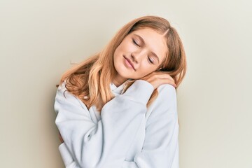 Obraz premium Beautiful young caucasian girl wearing casual sweatshirt hugging oneself happy and positive, smiling confident. self love and self care