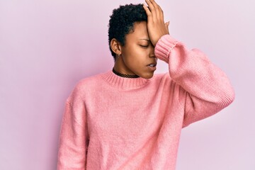 Young african american girl wearing casual clothes surprised with hand on head for mistake,...