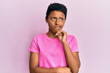 Fototapeta na wymiar Young african american girl wearing casual clothes serious face thinking about question with hand on chin, thoughtful about confusing idea