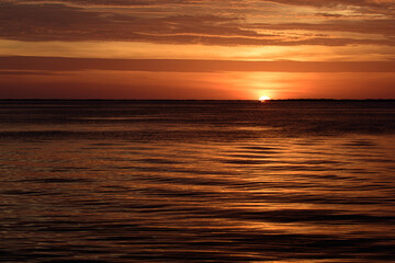 Fototapeta na wymiar Sunset sun over ocean water. Natural sky colors. Sunrise seascape.