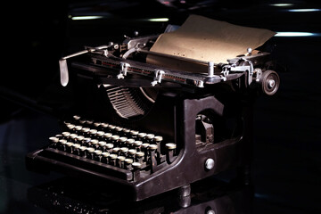 Vintage mechanical typewriter with Cyrillic keyboard layout with installed paper sheet on black background concept photography close-up view