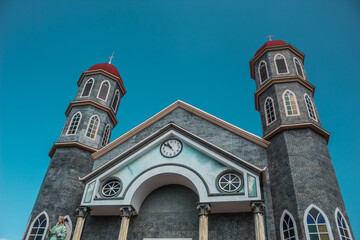 facade of an architectural building that corresponds to the church of San Rafael in Zarcero with a clear blue sky on a summer afternoon