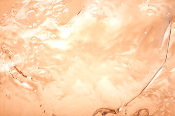Orange splashing cosmetic moisturizer, micellar water,  toner, or emulsion abstract background....