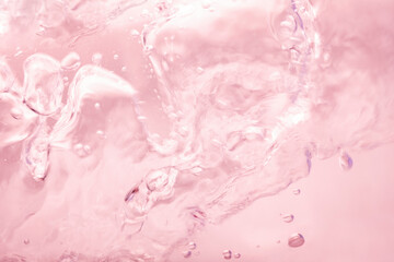 Pink splashing cosmetic moisturizer, micellar water,  toner, or emulsion abstract background....
