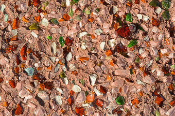  Stucco horizontal wall with green and brown glass pieces on brown wall back background.