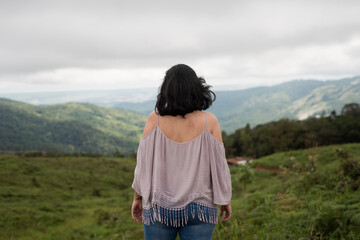 Naklejka premium woman looking at the horizon in the field, woman in the mountains.