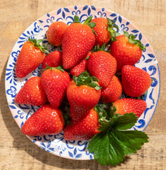 New harvest, plate of ripe red sweet strawberry ready to eat