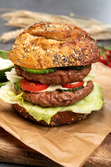 Tasty vegetarian vegan lunch with double decker hamburger made from plant based soya beans burger, organic bun with seeds and fresh vegetables
