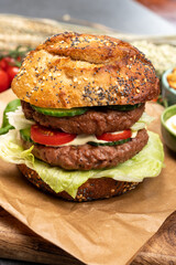 Tasty vegetarian vegan lunch with double decker hamburger made from plant based soya beans burger, organic bun with seeds and fresh vegetables